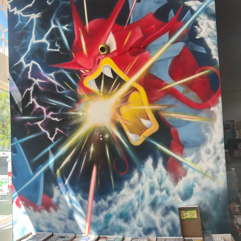 Hand-painted Gyarados mural above the bulk card bins at Waterfront Card Shop