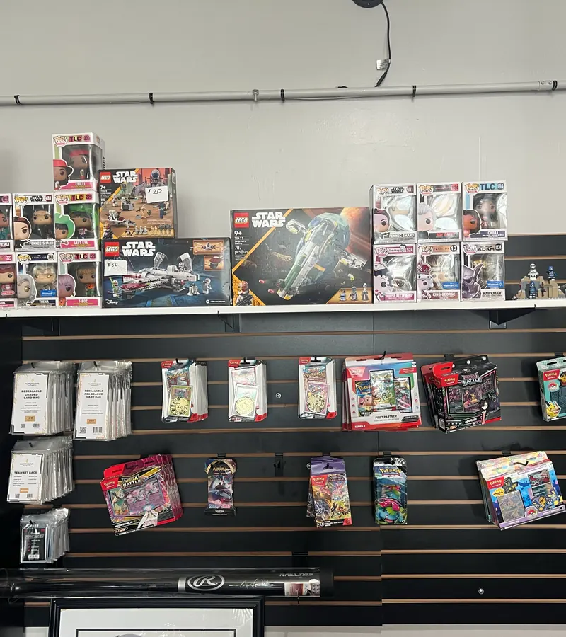 Slatwall with Pokémon blister packs, Funko Pop figures, LEGO sets and card supplies